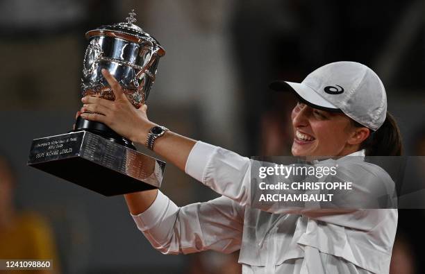 Poland's Iga Swiatek poses with the trophy after winning against US' Coco Gauff at the end of their women's single final match on day fourteen of the...