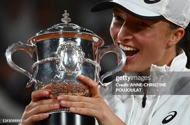 Poland's Iga Swiatek poses with the trophy after winning against US' Coco Gauff at the end of their women's single final match on day fourteen of the...