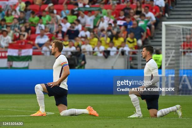 England's forward Harry Kane mand England's midfielder Mason Mount take a knee prior to the UEFA Nations League football match Hungary v England at...