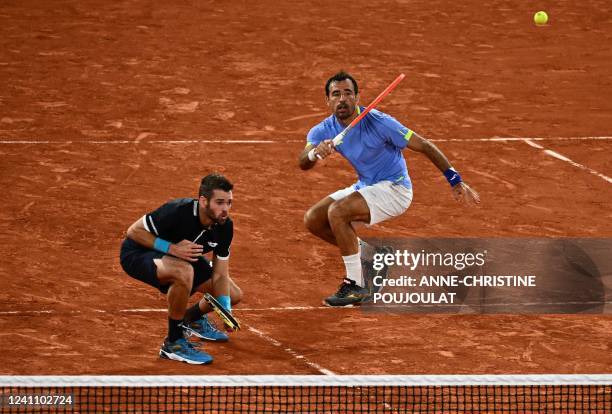 Croatia's Ivan Dodig returns next to his partner Austin Krajicek of the US to Netherlands' Jean-julien Rojer and Salvador's Marcelo Arevalo during...