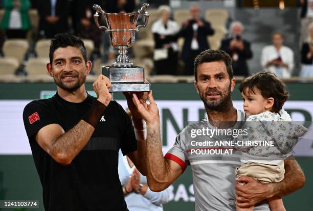 Salvador's Marcelo Arevalo and Netherlands' Jean-julien Rojer celebrate with the trophy after winning against Croatia's Ivan Dodig and Austin...