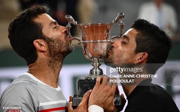 Salvador's Marcelo Arevalo and Netherlands' Jean-julien Rojer celebrate with their trophy after winning against Croatia's Ivan Dodig and Austin...