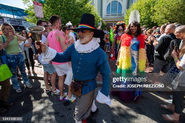 The town crier leads attendees as they march to a club to dance at a tea party during a pride rally in Provincetown, Massachusetts, on June 4, 2022.