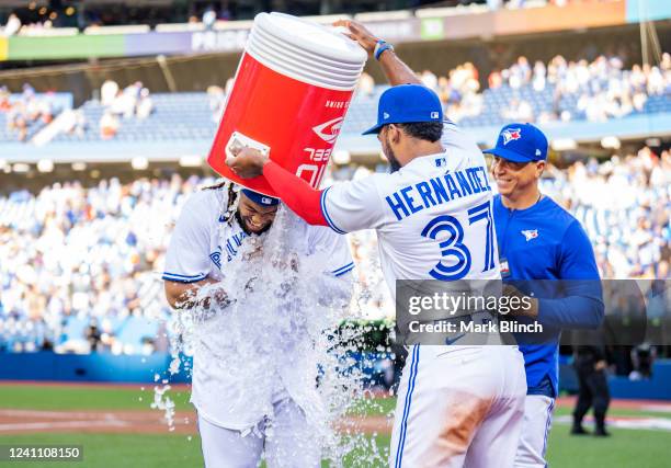 Vladimir Guerrero Jr. #27 of the Toronto Blue Jays gets water dumped on him by teammate Teoscar Hernandez after their team defeated the Minnesota...