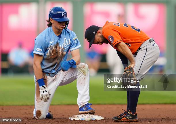 Jose Altuve of the Houston Astros reacts after being hit with the ball as Bobby Witt Jr. #7 of the Kansas City Royals looks on during the eighth...