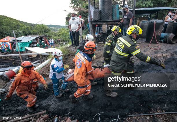 Members of the rescue teams carry the corpse of a miner in El Zulia, Norte de Santander department, Colombia, on the border with Venezuela, on June...