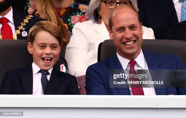 Britain's Prince George of Cambridge and Britain's Prince William, Duke of Cambridge react during the Platinum Party at Buckingham Palace on June 4,...