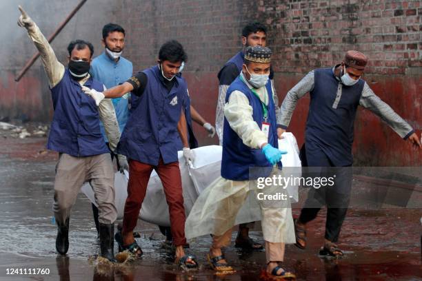 Rescuers carry the dead body of a victim from the site after a fire broke out at a container storage facility in Sitakunda, about 40 km from the key...