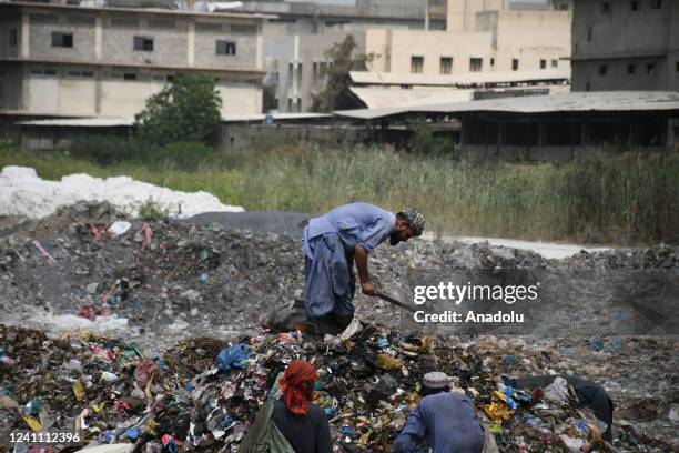 Pakistani garbage collectors collect usable items from a dump site on the eve of World Environment Day in Karachi on June 04, 2022. World Environment...