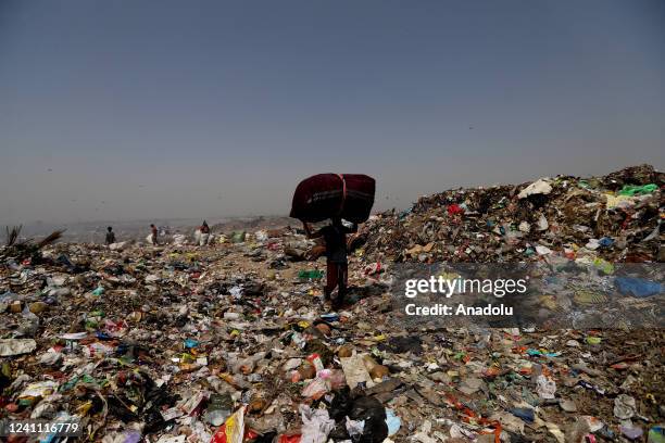 Rag picker carries recyclables collected from a garbage mound, at Bhalswa landfill on the outskirts of New Delhi, India on June 5, 2022. World...