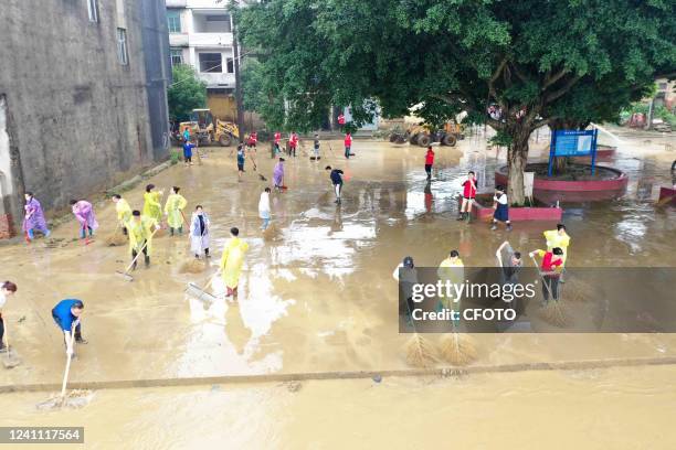 People clean silt from a riverbank in Liuzhou, South China's Guangxi Zhuang Autonomous Region, June 5, 2022.