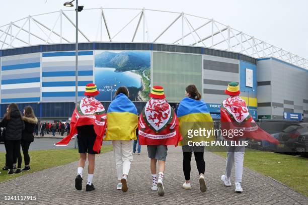 Wales and Ukraine supporters walk together outside the Cardiff City Stadium prior to the FIFA World Cup 2022 play-off final qualifier football match...