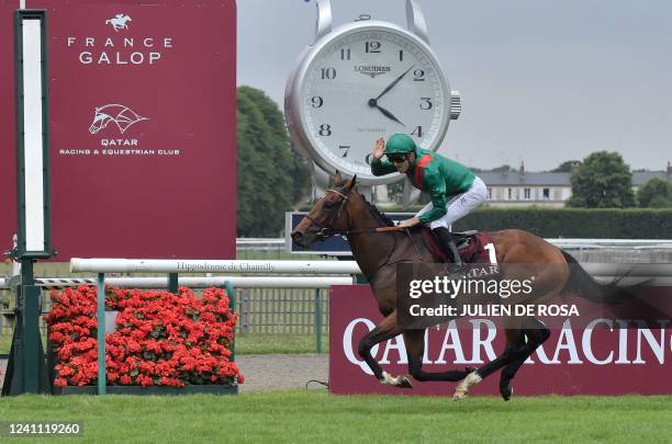 Belgian jockey Christophe Soumillon riding Vadeni crosses the finish line to win the 182nd edition of The Prix du Jockey-Club horse race at the...