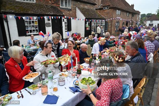 People attend a street party in Alfriston, East Sussex, on June 5, 2022 as part of Queen Elizabeth II's platinum jubilee celebrations. - Millions of...