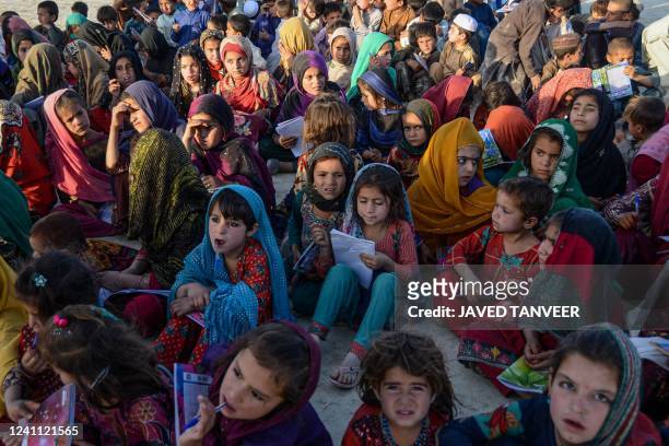 Afghan children attend a class on a mobile school in Kandahar on June 5 which is an initiative by volunteers wherein a vehicle carrying all sort of...