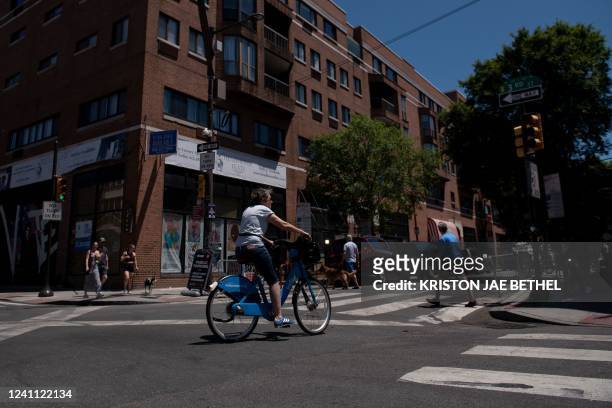 Bicyclist and pedestrians cross the intersection of South and 3rd Streets in Philadelphia, Pennsylvania, on June 5 the day after a mass shooting left...
