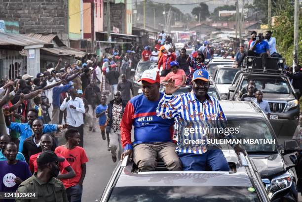 Azimio coalition party's Raila Odinga reacts to supporters with Nakuru county Governor Lee Kinyanjui during his rally after being officially...