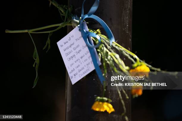 Note and flowers honoring the victims of a mass shooting in South Philadelphia are taped to a traffic light post at the corner of South and Third...