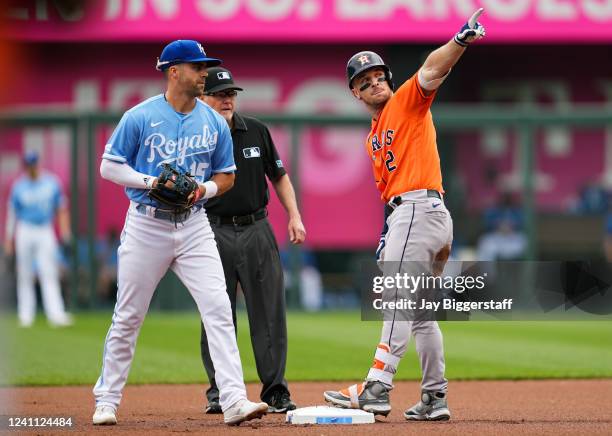 Alex Bregman of the Houston Astros signals to the dugout after hitting a double as Whit Merrifield of the Kansas City Royals looks on during the...