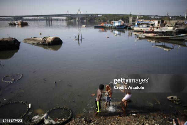 Children who live in the favela of Mare, north side of the city, help clean up the garbage in Guanabara Bay, and swim in the polluted waters, in Rio...