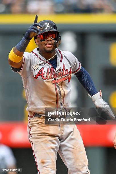Ronald Acuna Jr. #13 of the Atlanta Braves celebrates after stealing second base in the second inning of a game against the Colorado Rockies at Coors...