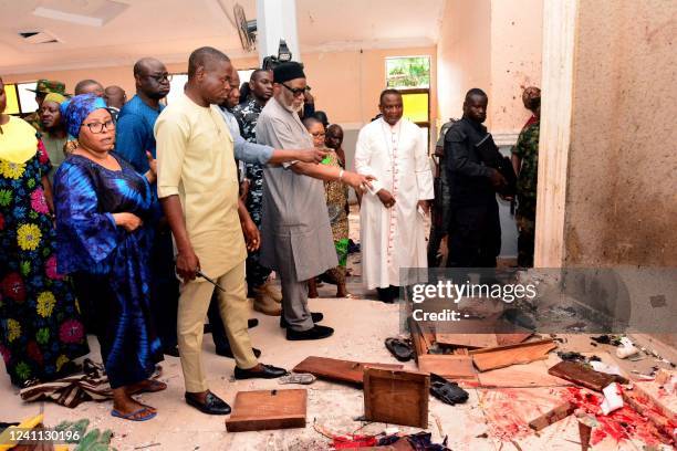 Graphic content / TOPSHOT - Ondo State governor Rotimi Akeredolu points to blood the stained floor after an attack by gunmen at St. Francis Catholic...