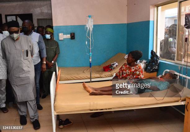 State officials walk past injured victims on hospital beds being treated for wounds following an attack by gunmen at St. Francis Catholic Church in...