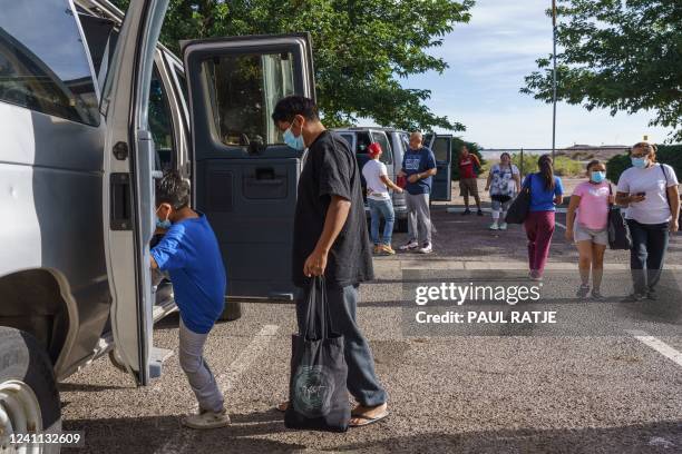 Families board vans to depart to the El Paso International Airport, where they will fly to their final destinations, at a motel used as a temporary...
