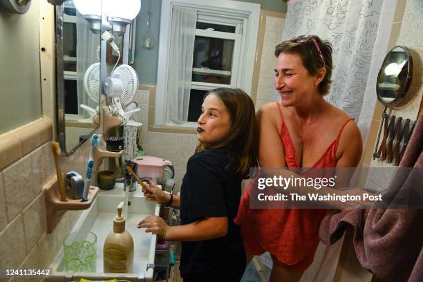 After a chemotherapy treatment day, Djohariah Singer shares a moment of joking around with her daughter Nalaina as the two of them brush their teeth...