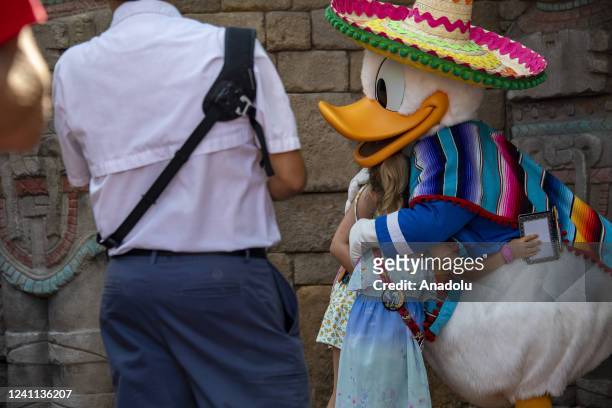 Donald Duck embraces children at a photo encounter during the Flower and Garden Festival at Epcot at Walt Disney World in Orange County, Florida on...