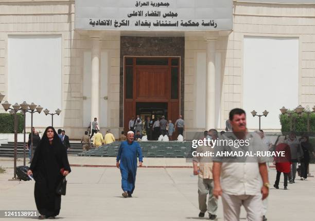 British and a German detainee, dressed in yellow prisoners' clothing and accused of smuggling antiquities out of Iraq, arrive to the Karkh Appeal...
