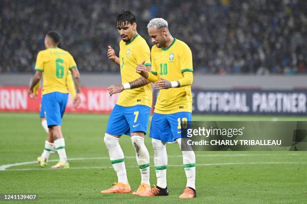 Brazil's forward Neymar dances with Brazil's midfielder Lucas Paqueta after scoring a goal in a penalty kick during the friendly football match...
