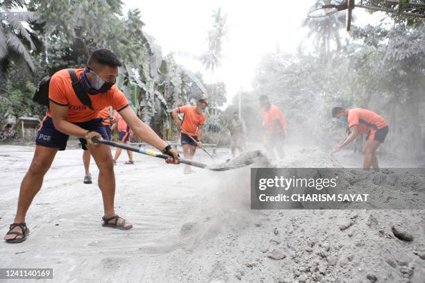 Coast guard personnel shovel ash to clear a road in Juban town, Sorsogon province on June 6 a day after the eruption of Bulusan volcano. - The...