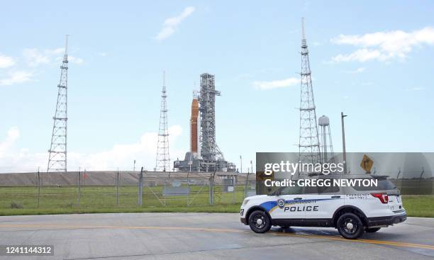 Security vehicle patrols near the fence perimeter of Launch Pad 39B where the massive Artemis I Space Launch System rocket sits after rolling out...