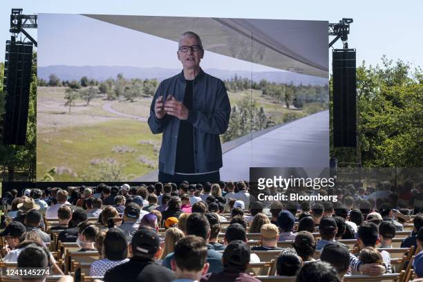 Tim Cook, chief executive officer of Apple Inc., displayed on a projection screen while speaking during the Apple Worldwide Developers Conference at...
