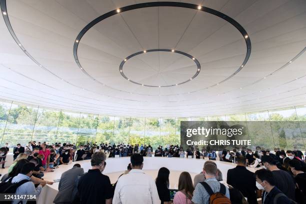 Attendies crowd around a display of new MacBook Airs inside the Steve Jobs Theater during the Apple Worldwide Developers Conference at the Apple Park...