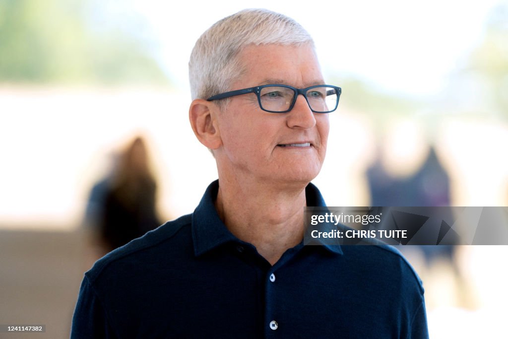 Apple CEO Tim Cook poses for a portrait next to a line of new MacBook ...