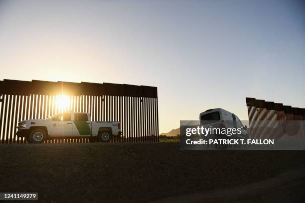 Border Patrol agent drives a van between a gap along the border wall between the US and Mexico in Yuma, Arizona on June 1, 2022. - The stream of...