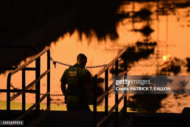 Customs and Border Protection Border Patrol agent patrols after sunset along a gap in the border wall at the Morelos Dam between the US and Mexico in...