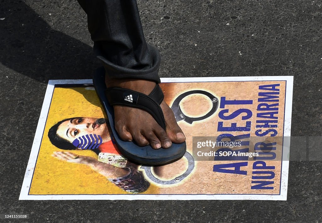 A protestor steps on a poster of Bharatiya Janata Party (BJP...