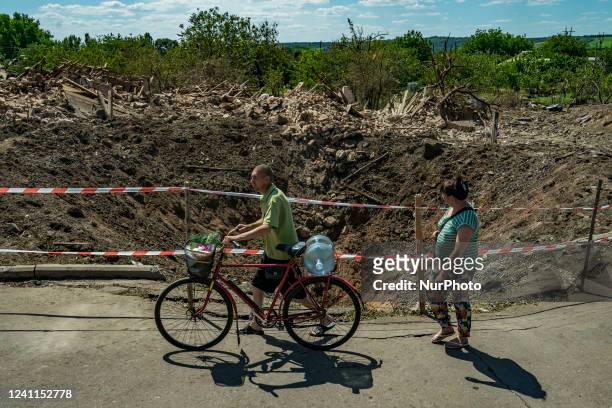 Civilians pass near a huge crater of a russian airstrike the last night over Druzhkivka city during the Russia´s war in Ukraine. The bomb fell over a...