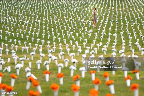 Jordan Costa, Giffords community violence initiative project manager, walks through a field of flowers representing deaths from gun violence at the...