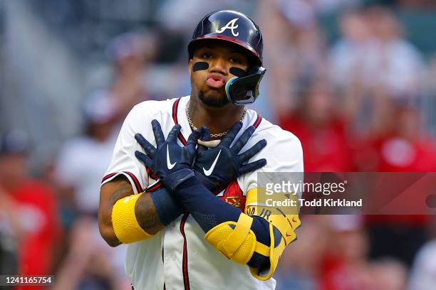 Ronald Acuna Jr. #13 of the Atlanta Braves reacts with a signature Trey Young, Ice Trey celebration after hitting a solo home run during the first...