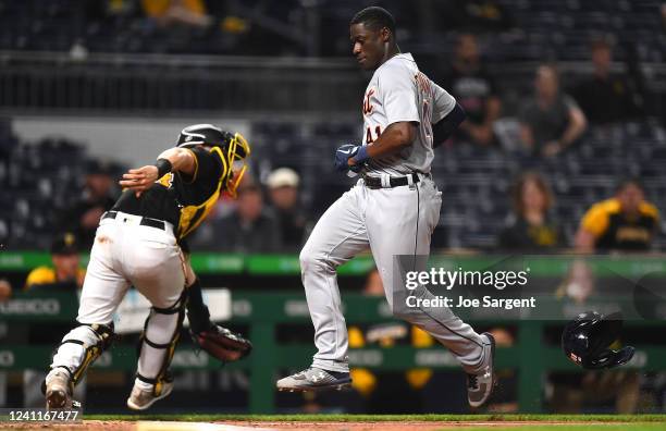 Daz Cameron of the Detroit Tigers scores in front of Tyler Heineman of the Pittsburgh Pirates during the eighth inning at PNC Park on June 7, 2022 in...