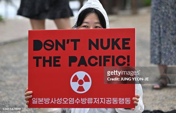 South Korean environmental activist holds a placard during a protest in Seoul against Japan's plan to discharge Fukushima radioactive water into the...