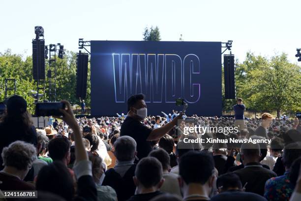 People attend a keynote address event during the 2022 Apple Worldwide Developers Conference WWDC22 at the Apple Park in Cupertino, California, the...