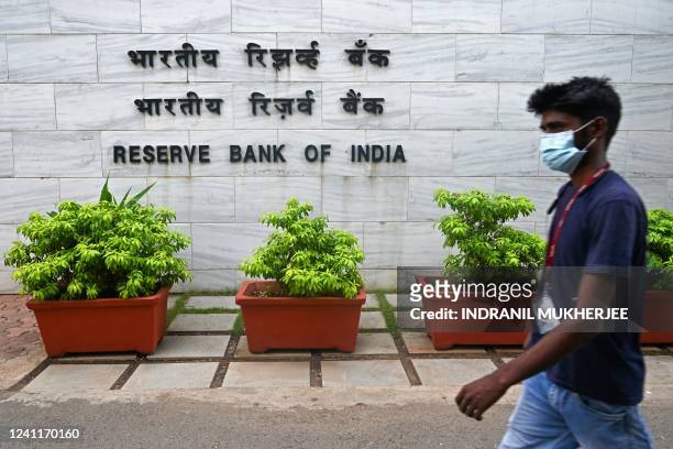 Pedestrian walks past the entrance of the Reserve Bank of India headquarters in Mumbai on June 8, 2022. - India's central bank on June 8 hiked rates...