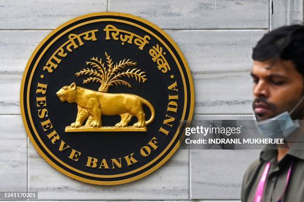 Pedestrian walks past the Reserve Bank of India signage at its headquarters in Mumbai on June 8, 2022. - India's central bank on June 8 hiked rates...