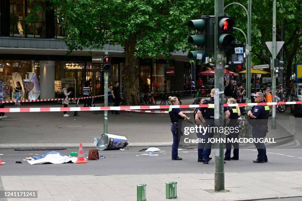 Police stand near the body of a dead person at a cordoned-off area where a car ploughed into a crowd near Tauentzienstrasse in central Berlin, on...