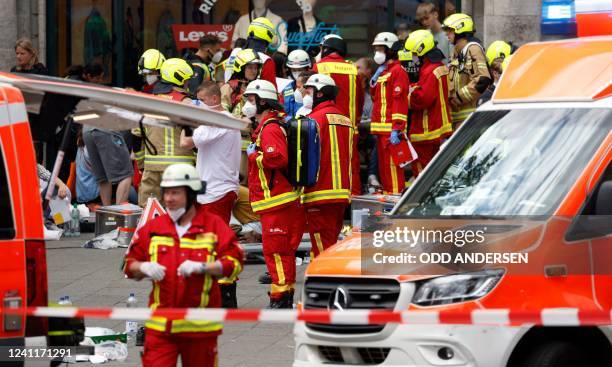 Rescue workers work at the site where one person was killed and eight injured when a car drove into a group of people in central Berlin, on June 8,...